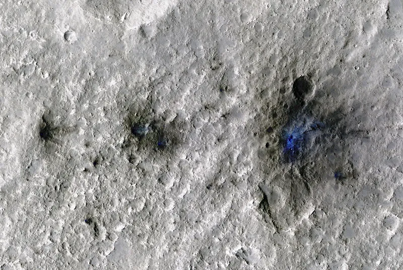 Martian craters formed by a Sept. 5, 2021, meteoroid impact, the first to be detected by NASA’s InSight. Taken by NASA’s Mars Reconnaissance Orbiter, this enhanced-color image highlights the dust and soil disturbed by the impact in blue in order to make details more visible to the human eye.