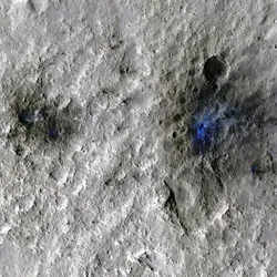 Martian craters formed by a Sept. 5, 2021, meteoroid impact, the first to be detected by NASA’s InSight. Taken by NASA’s Mars Reconnaissance Orbiter, this enhanced-color image highlights the dust and soil disturbed by the impact in blue in order to make details more visible to the human eye.