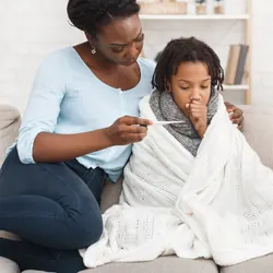 mother caring for sick child looking at thermometer