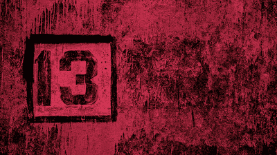 A black "13" painted on a reddish backrgound.