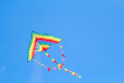 rainbow kite flying in blue sky
