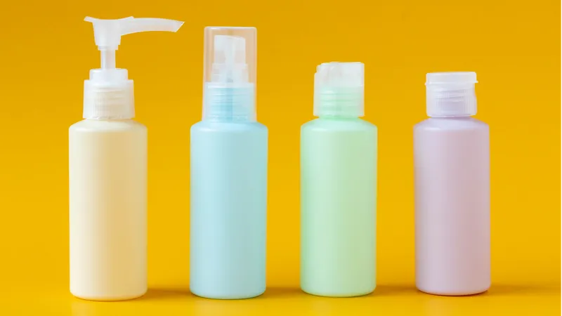 four small cosmetics bottles cleared for airport security, yellow background