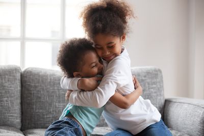 A sister and brother hug each other