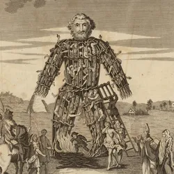 An 17th century engraving of a wicker man in a field. Its body is filled with people and a number of finely dressed individuals stand around it. 