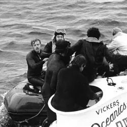 Divers assist rescued pilots from Pisces III as the reach the surface. 