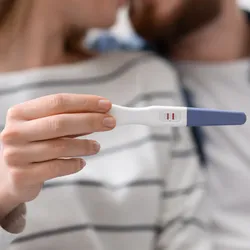 couple holding positive pregnancy test