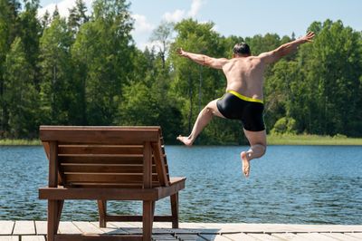 A man jumps into the water from the pier. Soft focus. Background image.