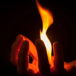 Human hand holding fire