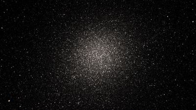 This image shows a star cluster set against a dark background. The further in towards the cluster’s centre, the higher the density of stars.