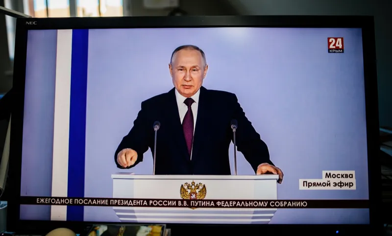 ffice desk with computer display Krym 24 station direct stream as Russian President Vladimir Putin speaks during his annual meeting with the Federal Assembly in February 2023.