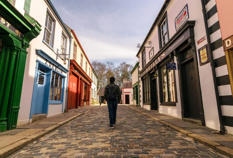A woman walking on empty streets of the old town of The Ulster American Folk Park in Omagh, County Tyrone, Northern Ireland 