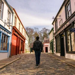 A woman walking on empty streets of the old town of The Ulster American Folk Park in Omagh, County Tyrone, Northern Ireland 
