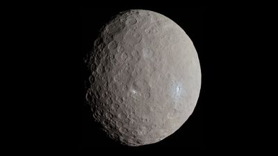 The dwarf planet is round with a cratered surface. Some region are bright and white evidence of geologicla activity like cryovolcanoes