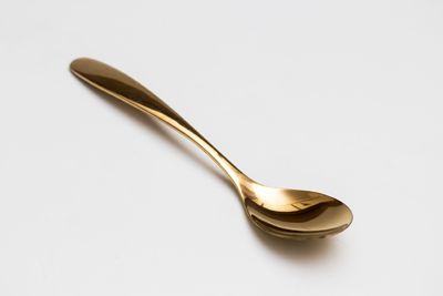 gold teaspoon on a white background