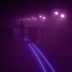Purple lights on a road at night in the dark.