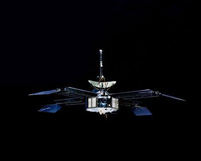 A spacecraft with an octagonal prism body four solar panel and an antenna on top.