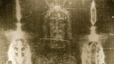 The Shroud of Turin, showing an eerie face-like pattern on cloth.