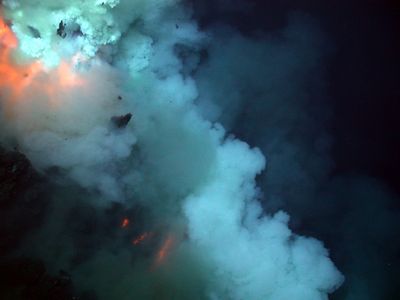 An eruption near the summit of the West Mata Volcano. The blast is in the top left portion of the image, and broken rock can be seen in the plume. The three red lines below the blast are bands of superheated lava flowing down the volcano's slope. Pacific Ocean, Northeast Lau Basin, Fiji area.