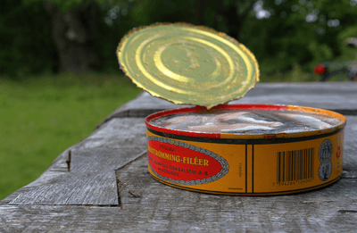 A red and orange can of Swedish Surströmming, a fermented fish that smells very strong