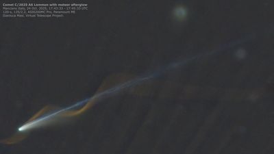 the comet is visible with a bright straight tail, and the helical red trail of a meteor looks like it is coiling along the comet.