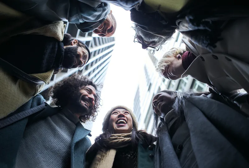 A group of people standing in a circle, imaged from below.