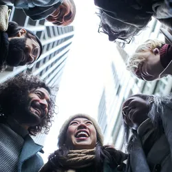 A group of people standing in a circle, imaged from below.