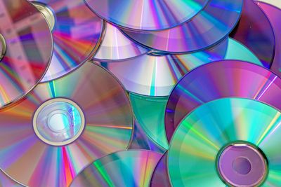 A pile of CD, compact discs, showing their shinyness.