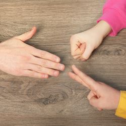 Closeup of people playing rock, paper and scissors on wooden background, top view