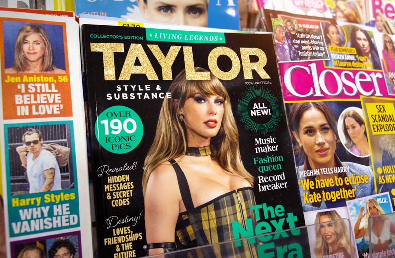 celebrity magazines on a shelf, with a close up on a cover featuring Taylor Swift