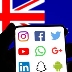 australian flag with a silhouette of a human hand in front of it holding a smartphone, containing the logos of social media platforms: instagram, facebook, the old twitter logo, youtube, whatsapp, google plus, linkedin, snapchat, and the android lodo