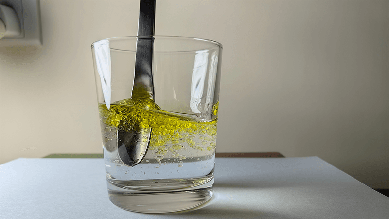 Oil floating in a glass of water.
