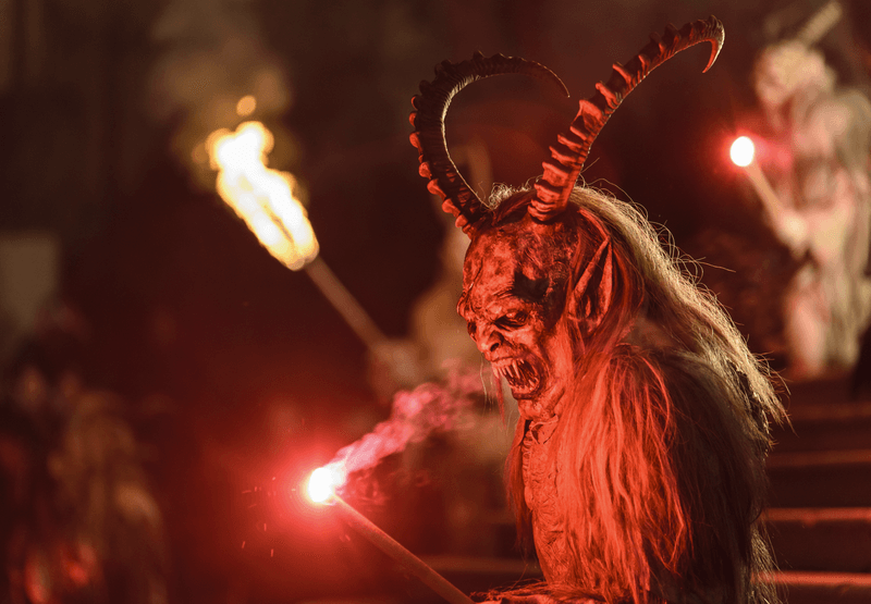 A devil character with a flame celebrating a Krampusnacht Christmas festival tradition in Europe