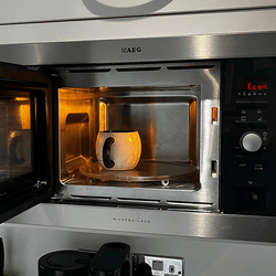A microwave with a mug inside it.