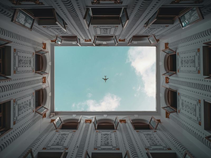 An airplane flies directly over a building's courtyard in Shanghai, China.