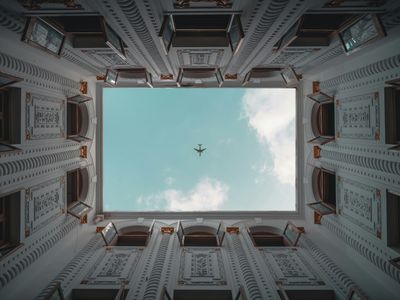 An airplane flies directly over a building's courtyard in Shanghai, China.