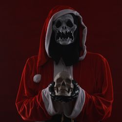 someone with a scary halloween mask on dressed up as santa