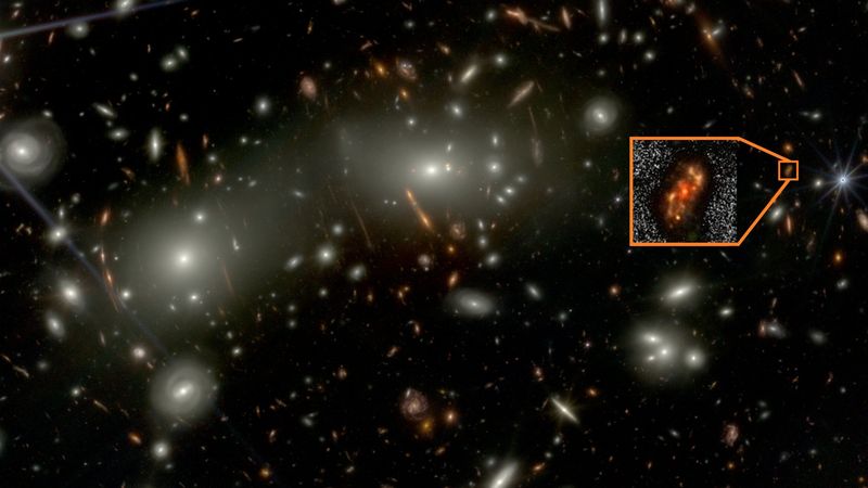 On a black background many galaxies are visible. The brighetest and closest are large and shine bright. Many small red galaxies are seen, among them , highlighted in an inset is Alaknanda. The inset show that it has a core and spiral arms.