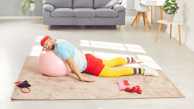 a man in workout clothes sleeps on an exercise ball