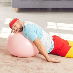 a man in workout clothes sleeps on an exercise ball