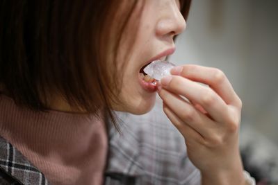 close up of woman eating an ice cube