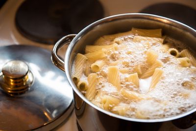 A large saucepan of penne-style pasta in boiling water