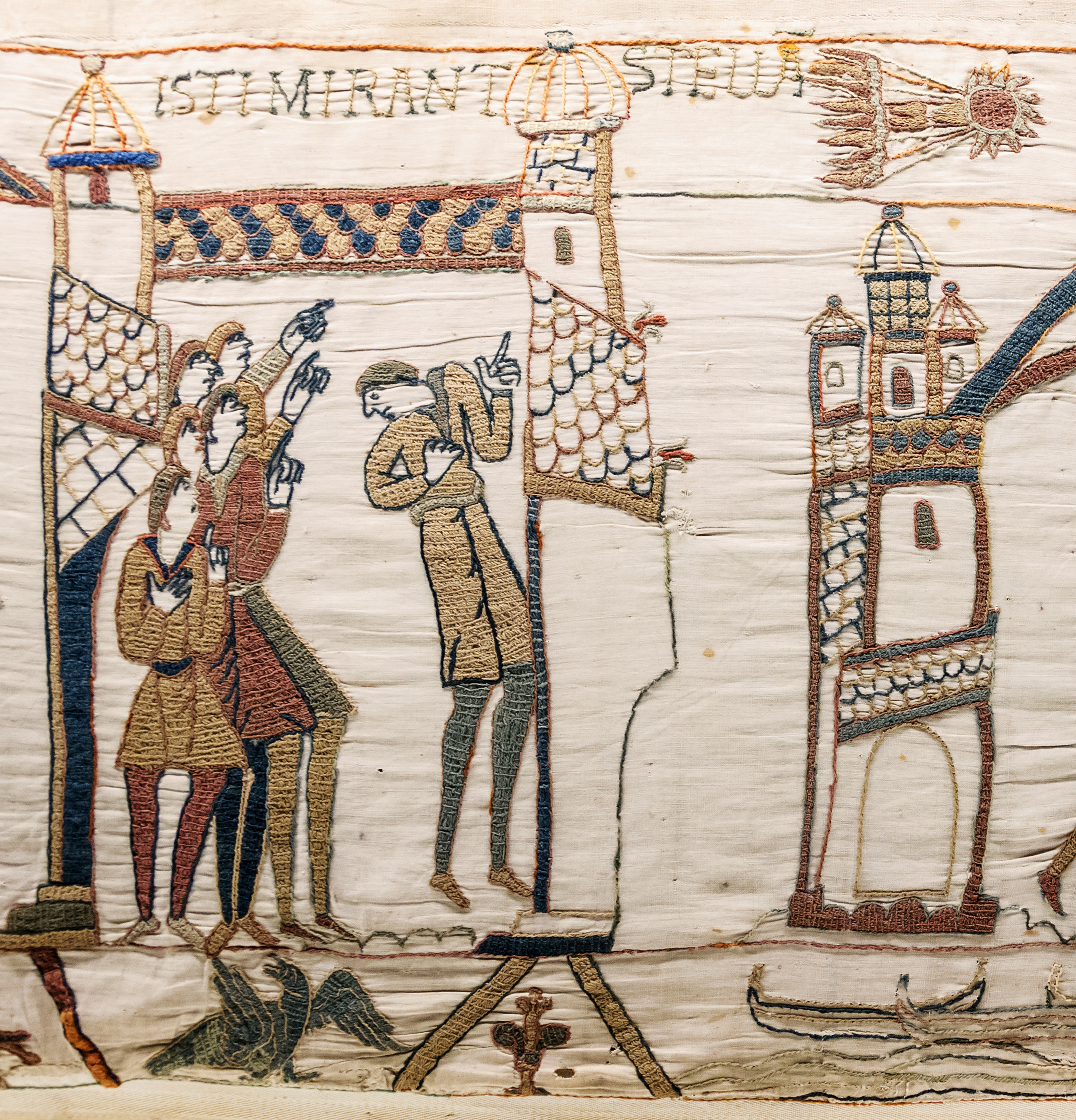 A portion of the tapestry showing a saw representaiton of the comet and sxi people inside a town point at the star. A portion of the tapestry showing a saw representaiton of the comet and sxi people inside a town point at the star.