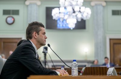 A photo of isaacman from the side. He's a white man in his 50s and he's sitting at a desk.