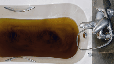 A bath filled with dirty water.