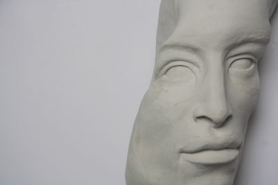 A photo showing the central facial features of a female statue, but has been cut away from the rest of the head so that it is presenting at an angle.