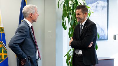 Wright and Isaacman standing a meter apart talking to each other.