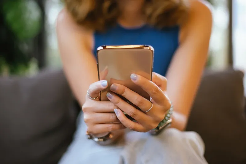 Close up of a woman's hands holding a cell phone