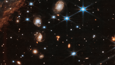 A collection of galaxies and stars. In the middle is a galaxy which really resembles a question mark.