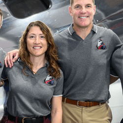 the four of them standing in front of the orion spacecraft.