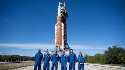 NASA astronaut Andre Douglas and CSA (Canadian Space Agency) astronaut Jenni Gibbons and prime crewmembers NASA astronauts Victor Glover, Reid Wiseman, CSA (Canadian Space Agency) astronaut Jeremy Hansen, and NASA astronaut Christina Koch, pose for a picture with NASA’s Space Launch System (SLS) rocket and Orion spacecraft,